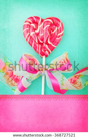 Heart shaped lollipop for Valentine's Day with turquoise background. Copy space background