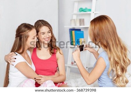 teen girls with smartphone taking picture at home