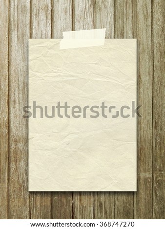 Close-up of one old vintage paper sheet with tape on vertical brown wooden boards background