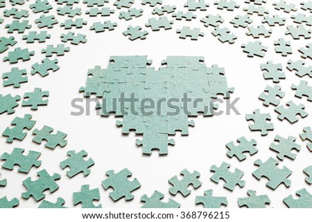 Silhouette of the heart, made with pieces of puzzle