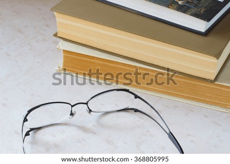 Old books and glasses on the desktop