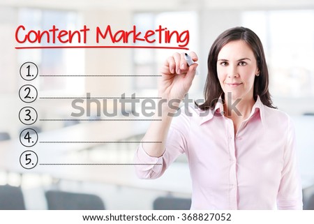 Business woman writing blank Content Marketing list. Office background. 