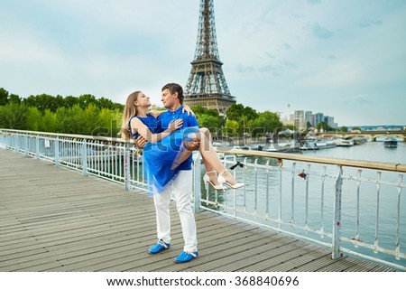 Romantic dating couple on a bridge over the Seine in Paris, Eiffel tower is in the background