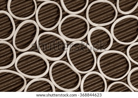 Sepia color image. Closeup white color rubber bands on small strips of red color paper texture or abstract background.