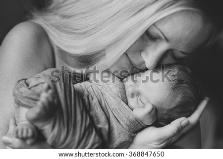 Newborn baby boy with mom, close up portrait on hands