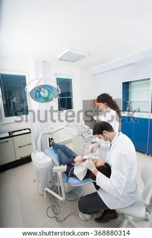 Male dentist, and female patient in dental practice