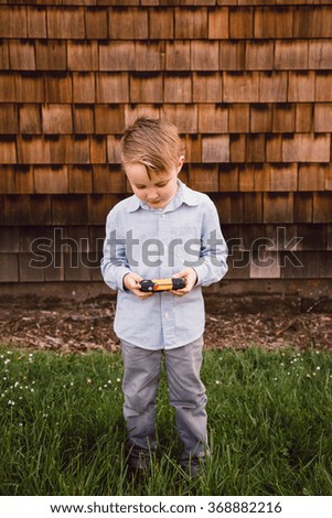 Young boy with a camera is a future photographer in this lifestyle portrait.