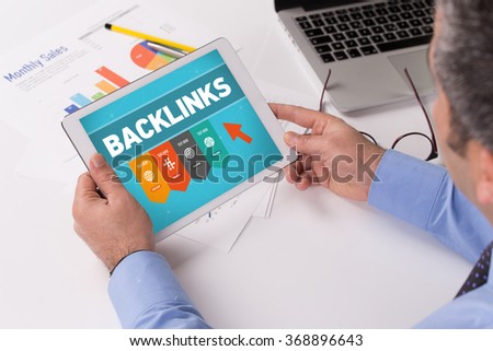 Man working on tablet with BACKLINKS on a screen