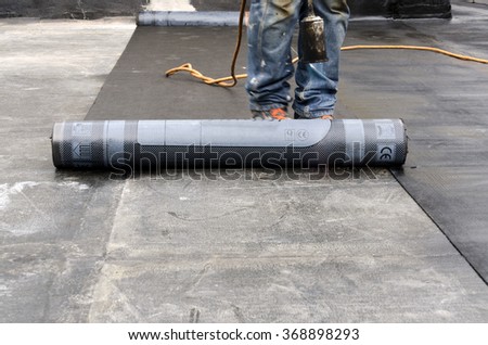 flame during welding of a waterproofing membrane on a roof Royalty-Free Stock Photo #368898293