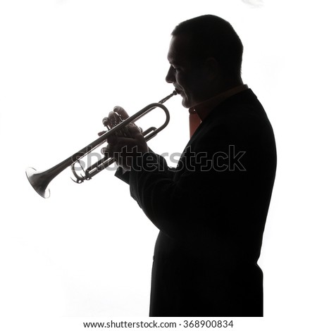 trumpet and player - young man playing a trumpet - back light - shadows - musical instruments - valves and tubes - mouthpiece for playing