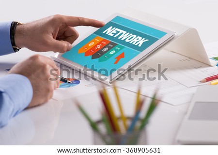 Businessman working on tablet with NETWORK on a screen