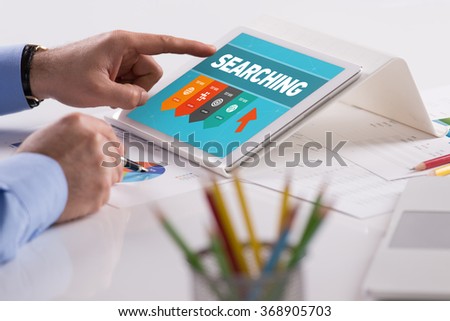 Businessman working on tablet with SEARCHING on a screen