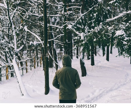 Man in jacket on the road in winter forest