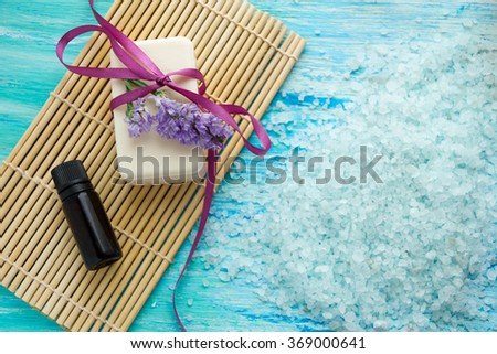 natural organic soap bottles essential oil and sea salt on a blue wooden table, Spa with flowers