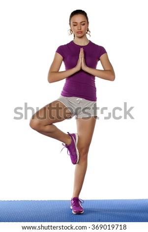 Attractive young sporty woman standing in yoga pose
