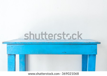 Old and dirty blue table in white room.