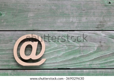 Wooden email symbol on grunge wood background (Commercial At Symbol)