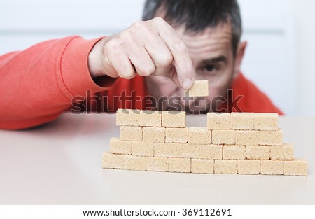 man stacking a piece of sugar Royalty-Free Stock Photo #369112691