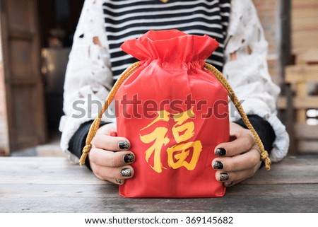 Vintage photo of asian woman holding red fabric bag for happy chinese new year.