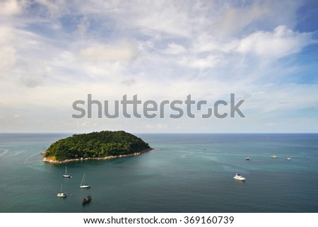 Beautiful little island in the blue sea with yachts