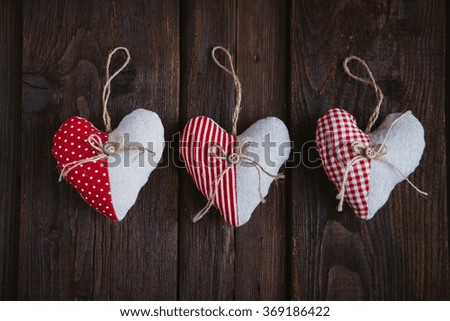 Hearts made of cloth with red white checkered pattern on rustic old wood with copy space, concept of love at Christmas, Mother's Day or Valentine's Day