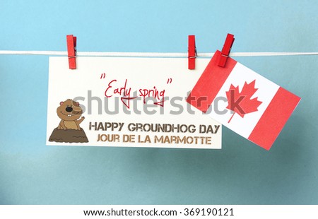 White envelope, cute face groundhog and text Happy Groundhog Day - Early spring. Canada flag hanging on colorful pegs clothespin. Jour de la Marmotte - Groundhog Day Canadian on French. Toned image