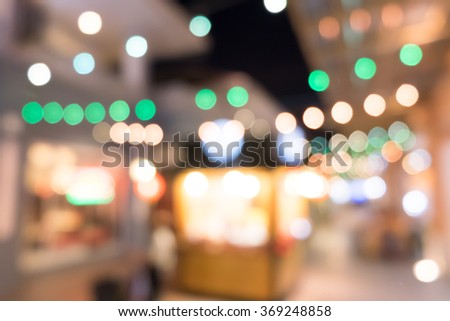 blurred background night market on street decorated with festive lights.