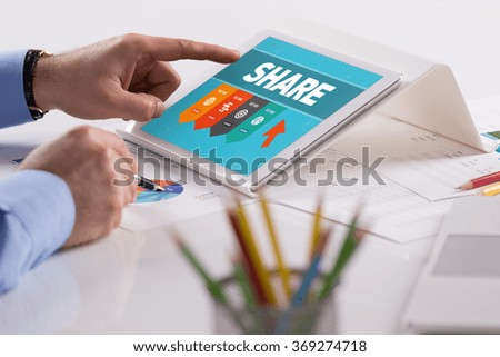 Businessman working on tablet with SHARE on a screen