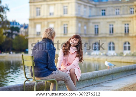 Young dating couple in the Luxembourg garden of Paris on a fall or spring day 