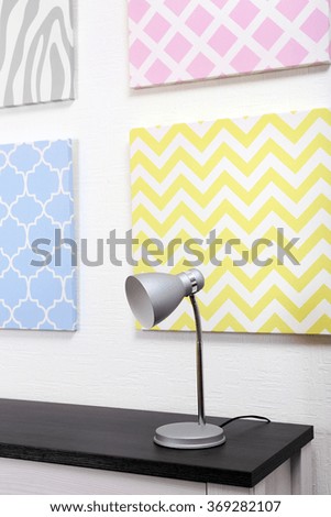 Table lamp and pictures in light room