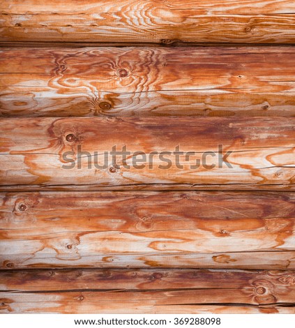 Close-up picture with wall of wooden logs. Colorful orange background or texture