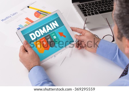 Man working on tablet with DOMAIN on a screen