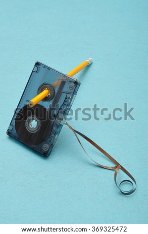 Old broken cassette  that was used for recording music on the isolated against a blue background