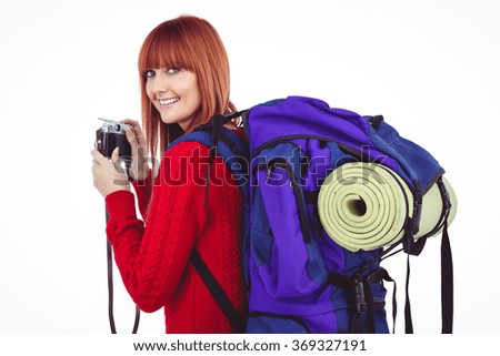 Smiling hipster woman with a travel bag against white background