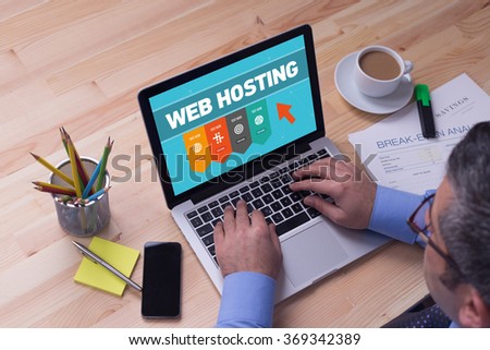 Man working on laptop with WEB HOSTING on a screen