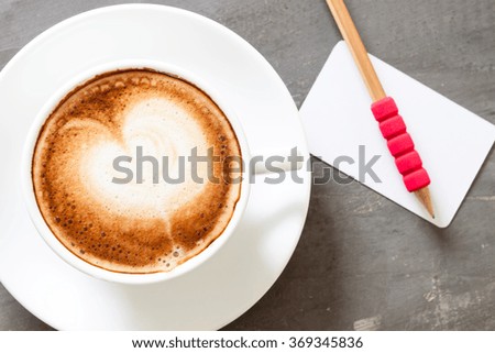 Coffee cup with name card on grey background, stock photo