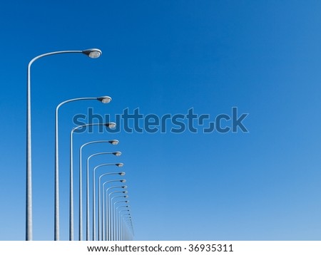 street lamps aligned with beautiful blue sky in background