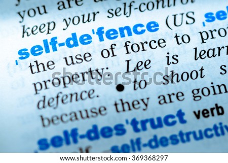 Close-up of word in English dictionary. Self defence, definition and transcription