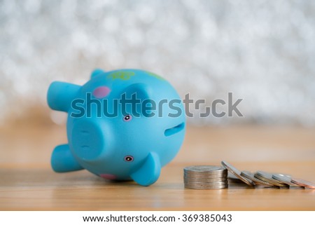 Piggy bank broken down with coins on wooden table, concept for business failure or down