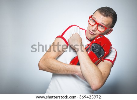 Childish man plays with toy car, immature man over gray background. Funny guy. Nerd