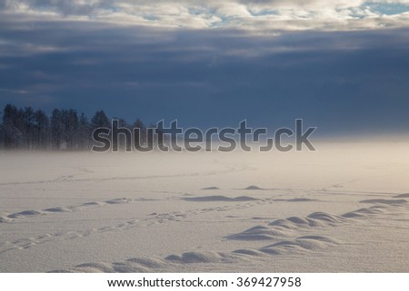 Mist over the lake with impressive clouds during the winter