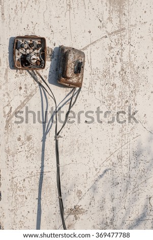 destroyed electrical devices on scratched wall of abandoned building. Vertical picture