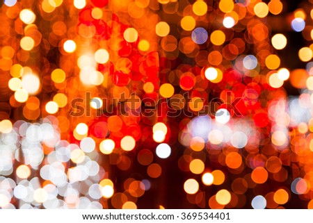 Colorful festive bokeh background of a defocused blurred city lights in shades of red, orange and white in a full frame view.