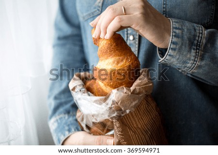 Women hand holding fresh and tasty roll croissants