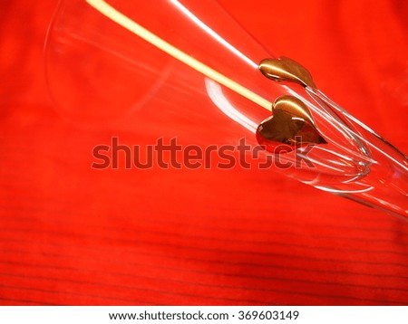 Two golden hearts (detail of a fancy glass) on a red background