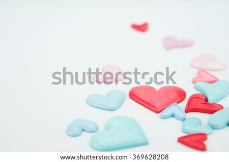 Valentines day wallpaper.Colorful, light pink, blue and red love hearts on white paper background.