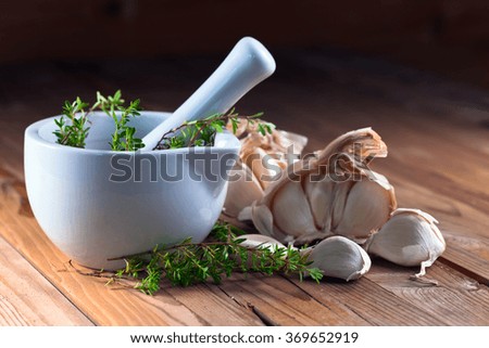garlic and  ceramic mortar with green thyme