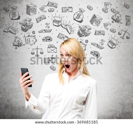 woman looking at her smartphone with an open mouth in amazement, black pictures symbolizing money around her. Concrete background. Front view. Concept of running into money.