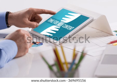 Businessman working on tablet with TIME FOR NEW CONTENT on a screen