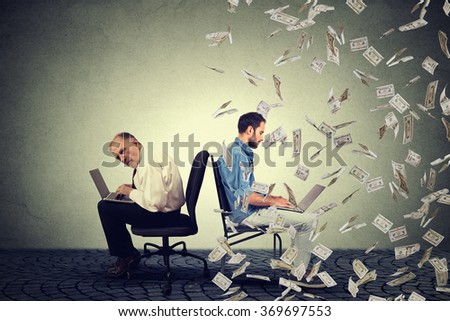 Employee compensation economy concept. Senior man working on laptop sitting next to young entrepreneur guy using computer under money rain. Pay difference concept. 